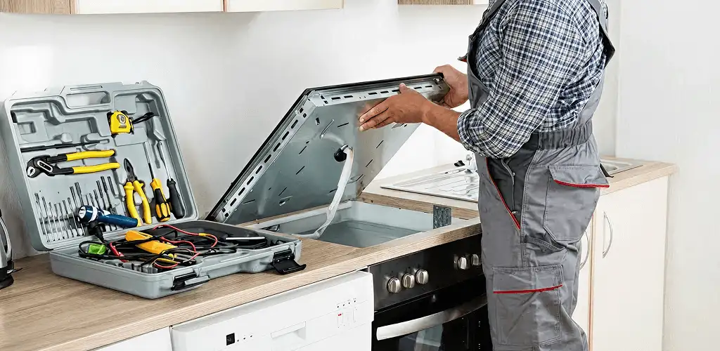 Handyman repairing a cooktop and checking wiring connections in Gilbert, AZ