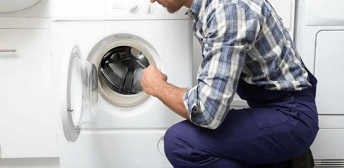 Handyman inspecting a dryer drum and internal parts for repair in Gilbert, AZ