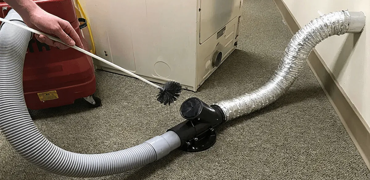 Dryer vent cleaning service removing lint from a dryer duct connection in Gilbert, AZ