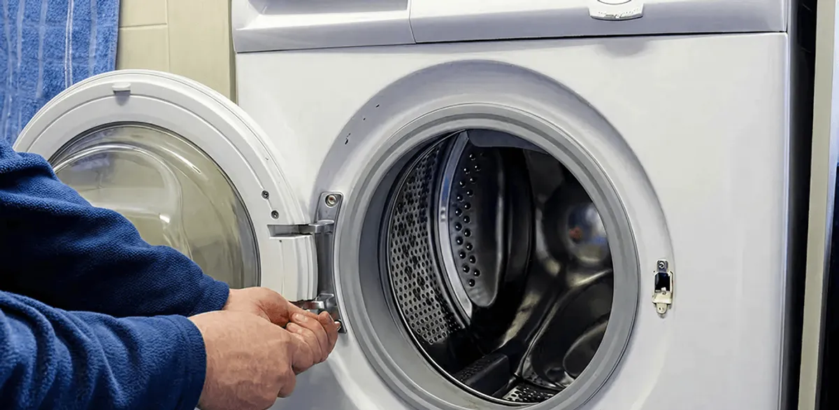 Washing machine repair handyman checking a front-load washer door and latch in Gilbert, AZ