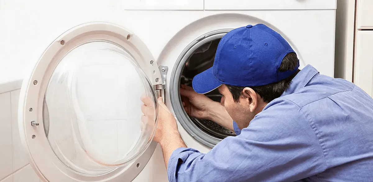 Washing machine repair handyman inspecting a front-load washer drum in Gilbert, AZ